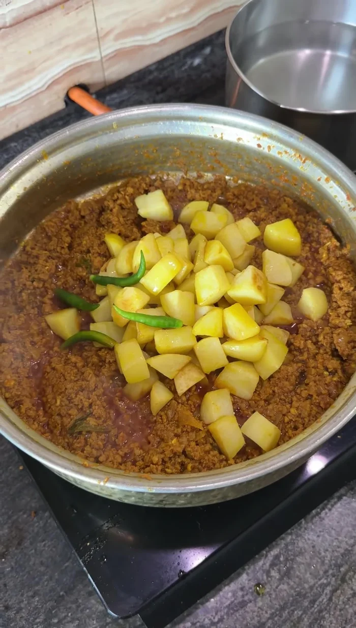 Agrega las papas fritas reservadas y algunos chiles verdes. Mezcla bien y añade un poco de agua caliente.