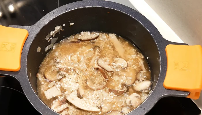 Añadir un poco de caldo (o agua) para cubrir el arroz y cocinar a fuego lento.