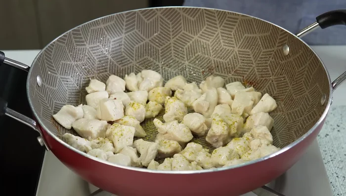 Condimentar el pollo con curry, cúrcuma, sal, pimentón y pimienta negra. Bajar el fuego y dejar sofreír (238.879).