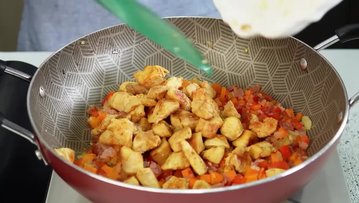 Incorporar el pollo sofrito a la sartén (388.56).