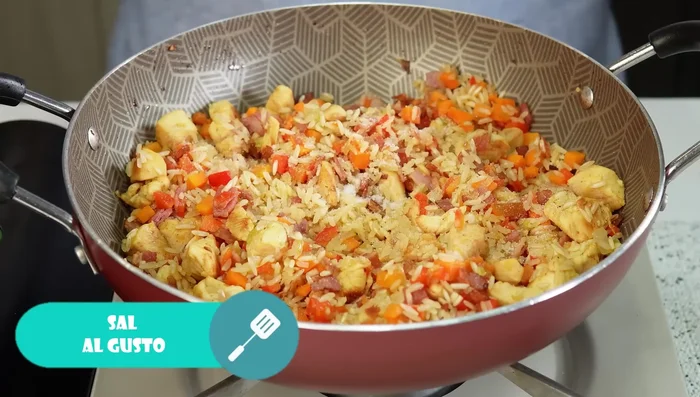 Agregar sal, pimentón y agua caliente (el doble de la cantidad de arroz) (423.24). Mezclar y tapar parcialmente.
