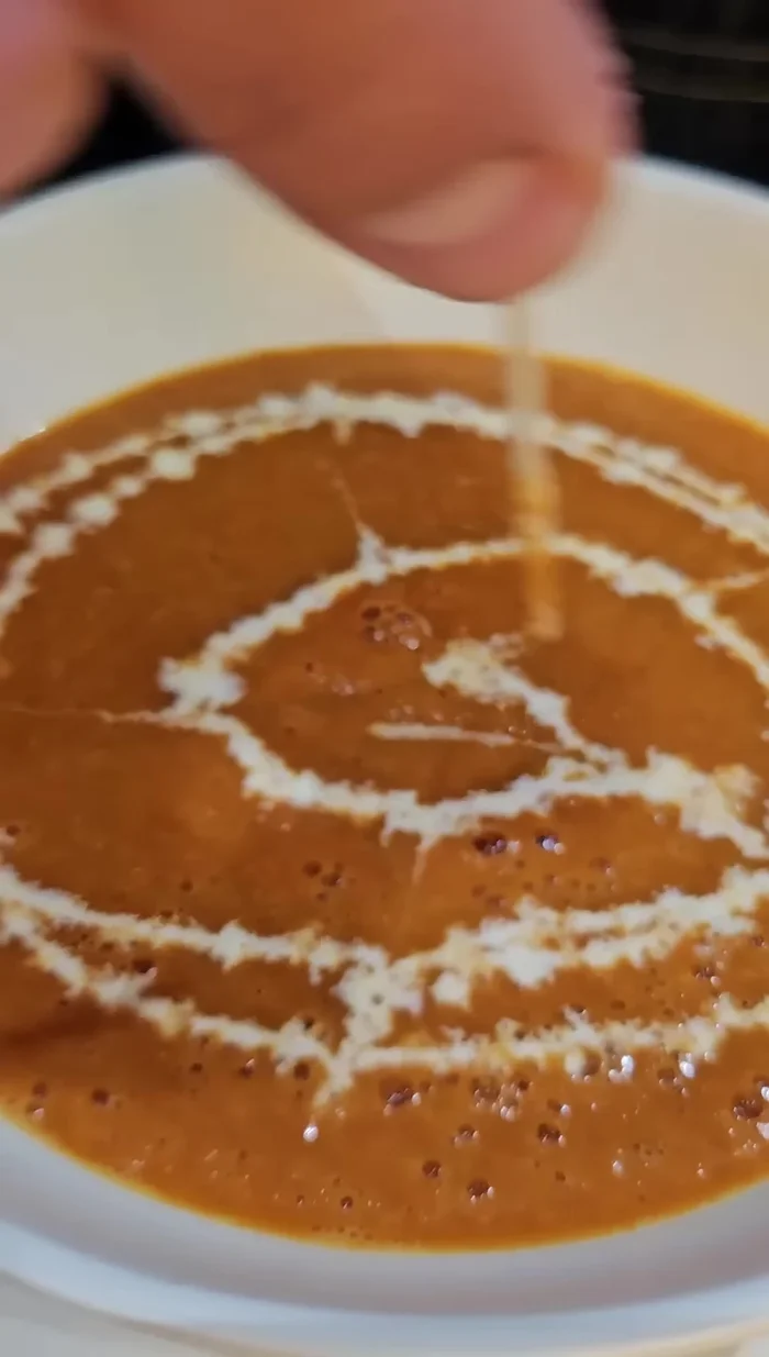 Servir la sopa caliente, decorando con un toque de crema y albahaca fresca. Acompañar con el sándwich de queso derretido.