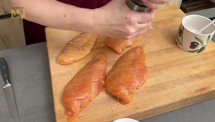 Hacer unos cortes en la parte superior de las pechugas y salpimentar. [70.4]