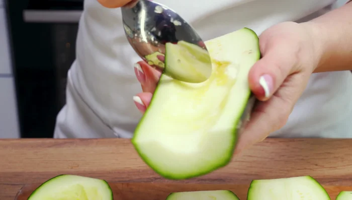 Cortar los calabacines por la mitad, retirar la piel y el centro con una cuchara. Reservar la pulpa.