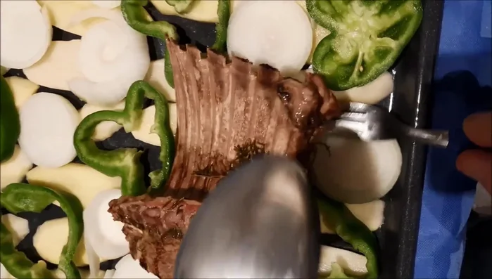 Retirar el cordero del horno y colocarlo junto con las papas y cebollas.