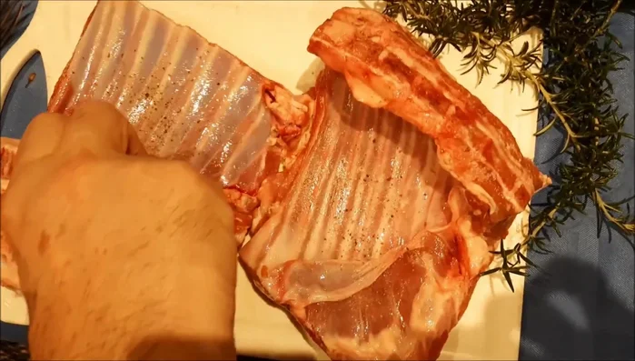 Salpimentar el costillar de cordero.