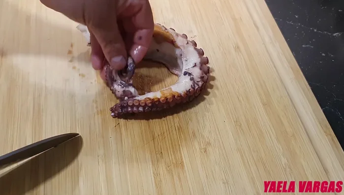 Cortar el pulpo: Cortar la punta de un tentáculo para decorar. Cortar el resto del pulpo en rodajas de aproximadamente 1 centímetro de grosor.
