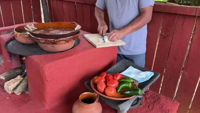 Mientras se cocinan las lentejas y la carne, picar finamente la cebolla, los chiles jalapeños y serranos, y los jitomates.
