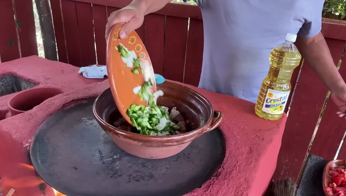 Agregar la cebolla y los chiles picados a la carne y dorarlos.