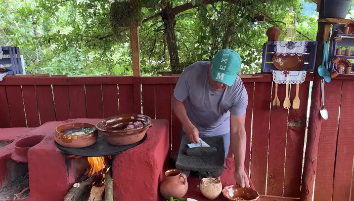 En otra cazuela, cocinar la carne de puerco con hojas de laurel, media cebolla y sal hasta que se consuma el agua.
