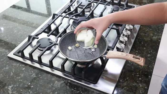 En una sartén con aceite, sofreír el ajo, la cebolla y el chile verde hasta que estén dorados.