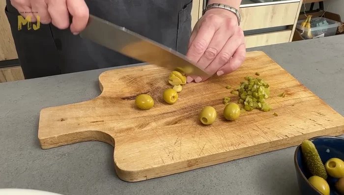 En un bol, mezclar las patatas, la zanahoria, los pepinillos, las aceitunas, el pulpo picado y las yemas (crushed). Añadir sal al gusto.