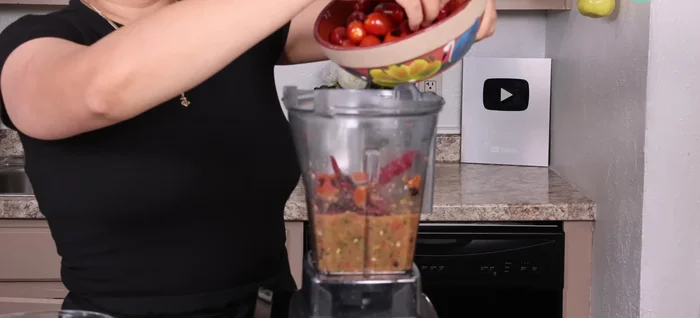 Agregar los chiles de árbol y los tomates uva a la licuadora. Licuar ligeramente.