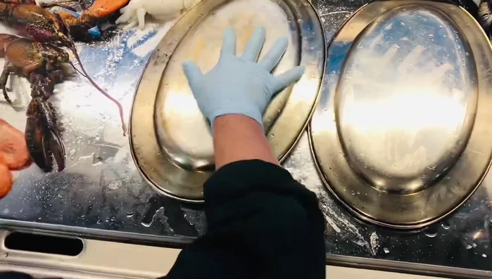 Tapar la plancha para que los mariscos se abran bien.