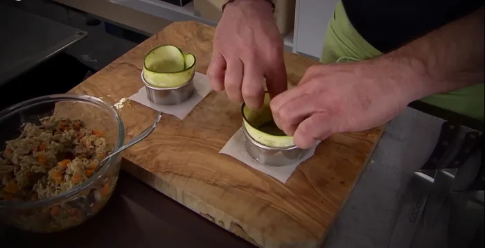 En un molde para hornear, coloca una lámina de calabacín como base, rellena con el ragú y cubre con otra lámina de calabacín.