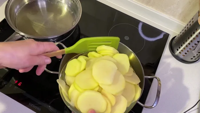 Calentar aceite en dos sartenes a fuego medio-bajo. En una sartén, freír las patatas hasta que estén doradas.