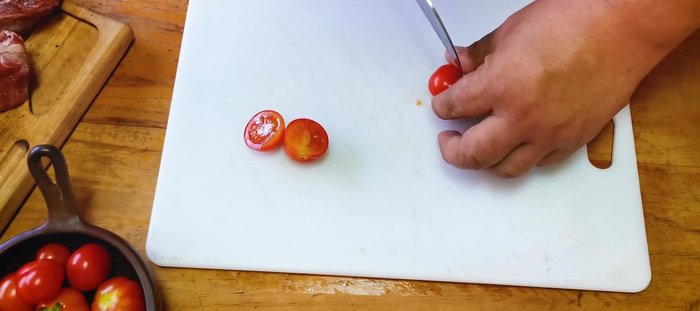 Preparación de los tomates cherry: Cortar los tomatitos cherry por la mitad y saltearlos en una sartén con aceite de oliva, ajo y tomillo.