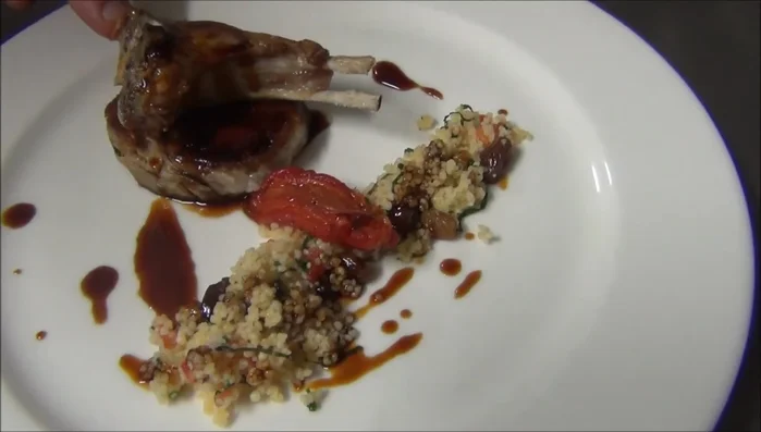 Servir el cordero con el cuscús, la salsa reducida y las chuletillas a la plancha. (332.199)