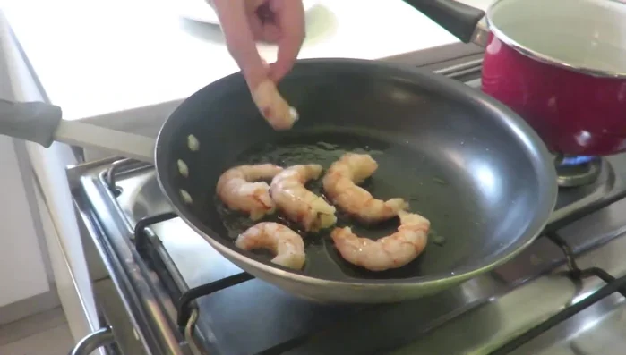 Freír los langostinos en aceite caliente hasta que estén dorados, moviéndolos constantemente.