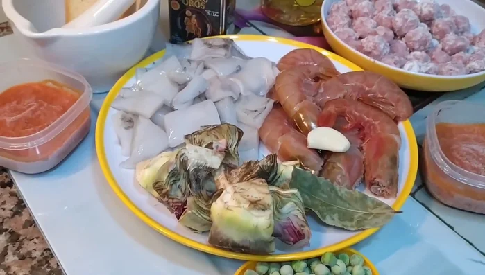 En la olla, añadir el aceite de las gambas y la sepia, y sofreír un poco las albóndigas.