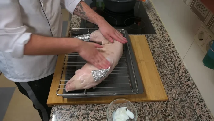 Untar la manteca de cerdo por toda la piel del cochinillo hasta que quede brillante y blanquecina.