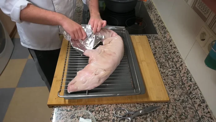 Cubrir las patas, orejas y rabo (si lo tiene) con papel aluminio para evitar que se quemen durante la cocción.