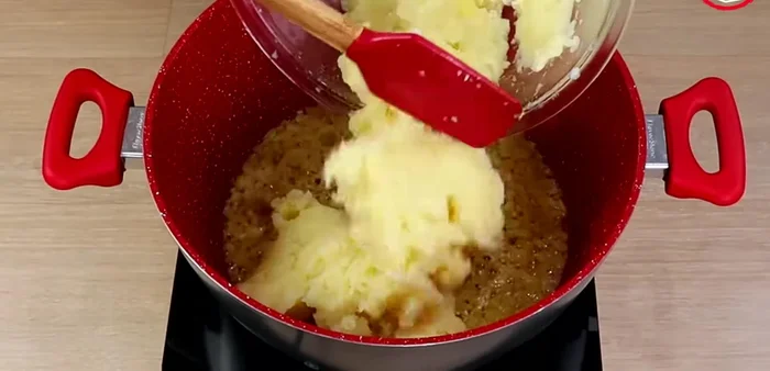 Agregar papas cocidas y picadas a la olla. Incorporar crema de leche, leche, sal y nuez moscada. Cocinar entre 5 y 7 minutos.