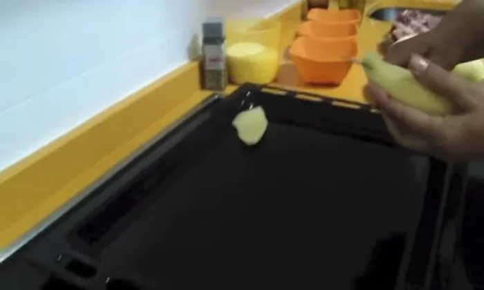 Pelar las patatas y cortarlas en trozos. Colocarlas en una bandeja de horno.