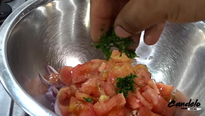 Preparar la ensalada de aguacate: mezclar cebolla, tomate, sal, pimienta, cilantro, zumo de limón y aceite de oliva. Agregar el aguacate cortado en cubos.