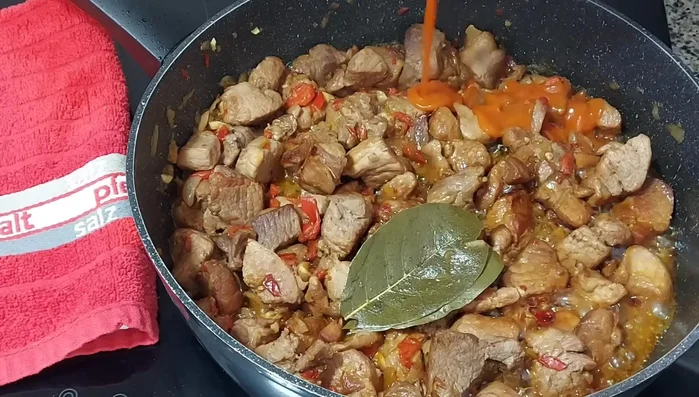 Una vez tierna, bajar el fuego, añadir el tomate frito y mezclar bien para que se impregne en la carne.