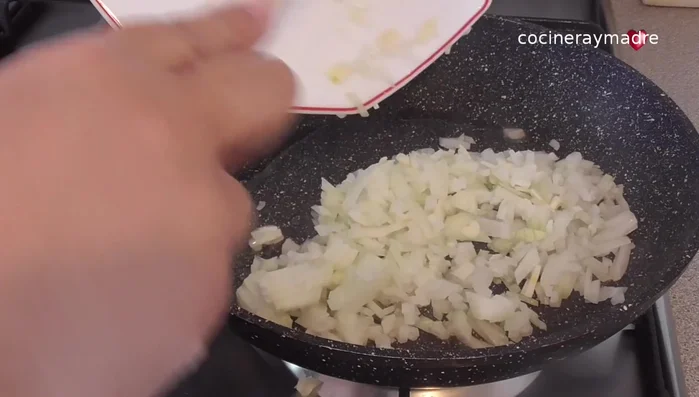 En la misma sartén, sofreír el ajo y la cebolla con una pizca de sal. Si es necesario, añadir un poco más de aceite. Tapar y cocinar a fuego lento hasta que la cebolla esté blanda (unos minutos).