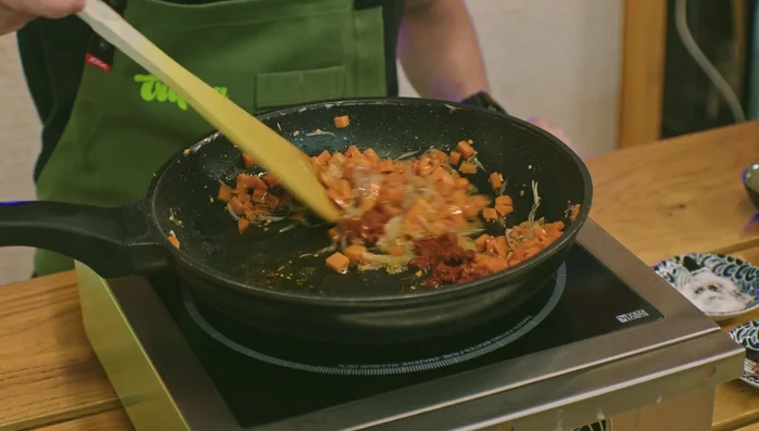 Agregar la pasta de curry rojo, azafrán y cúrcuma, rehogar brevemente (99.54).