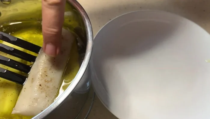 Retirar la merluza del aceite después de 7 minutos. Retirar el ajo y el romero del aceite.