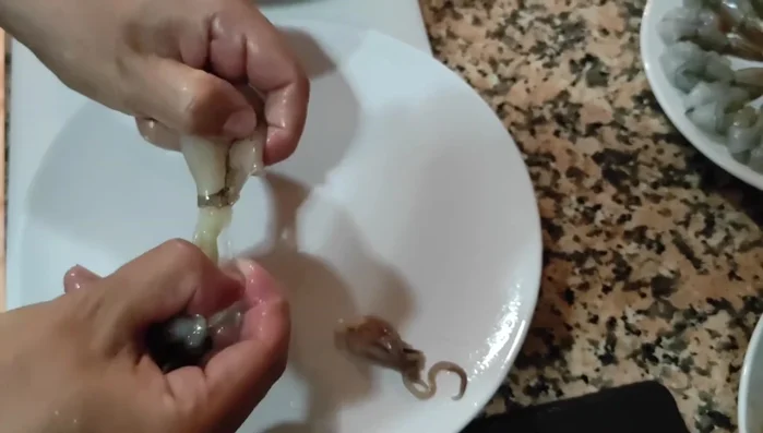 Limpiar los chipirones, quitando las patitas, la pluma y las vísceras. Retirar la piel y limpiar bien. (109.15)