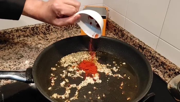 En la misma sartén, sofreír el ajo picado, añadir el pimentón, la cebolla, el pimiento verde y el pimiento rojo. Saltear hasta que estén rehogados. Incorporar las hojas de laurel, sal y pimienta. (458.59)