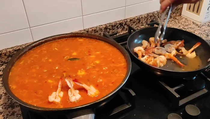 Incorporar los langostinos al arroz y añadir el jugo que hayan soltado. (666.399)
