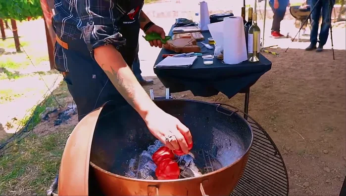 Prepara los pimientos y chiles jalapeños: Asa los pimientos y chiles directamente en la brasa hasta que se les queme la piel. (43.62)