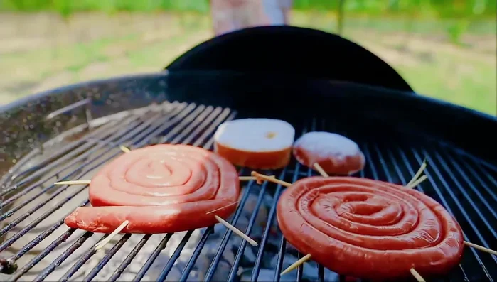 Cocina la chistorra: Asa la chistorra a fuego indirecto (unos 15 minutos), dándole vueltas hasta que esté dorada y bien hecha. (71.119)