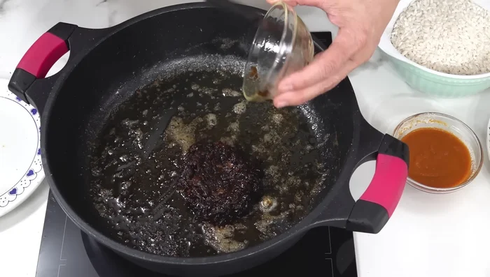 Añadir la cebolla caramelizada y la salmorreta a la cazuela.