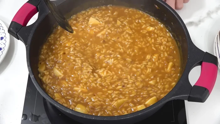 Una vez cocido el arroz, apagar el fuego, añadir los gambones reservados y remover.
