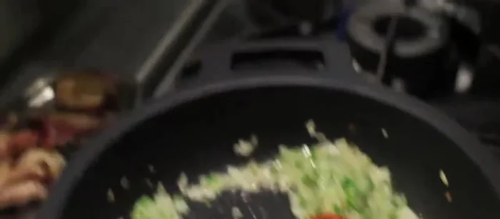 Agregar el sofrito a la pallera con el pichón dorado.