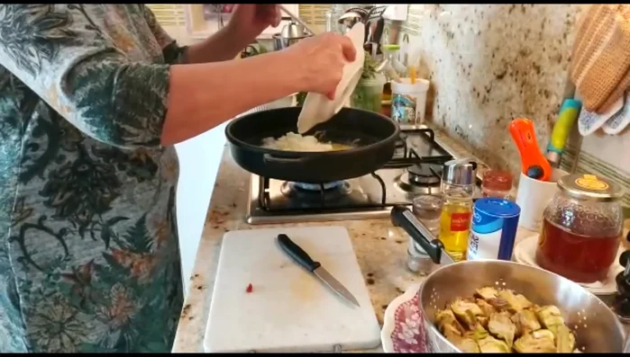 Cuando la sepia esté casi hecha, añadir la cebolla y los ajos picados.