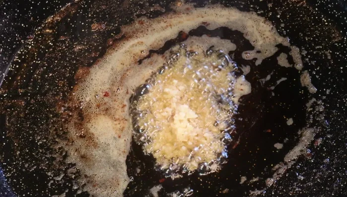 En la grasa del foie y del pato, sofreír el ajo picado. Añadir una cucharada de cebolla caramelizada y el tomate rallado. Cocinar hasta que reduzca el agua.