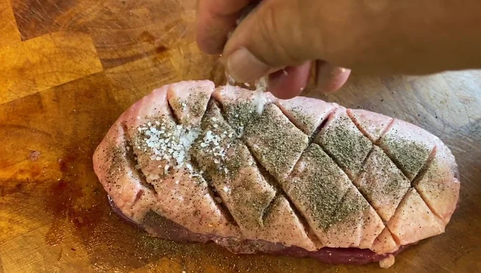Sazonar los magret de pato con sal gruesa y pimienta negra molida, haciendo cortes diagonales y cruzados en la piel.