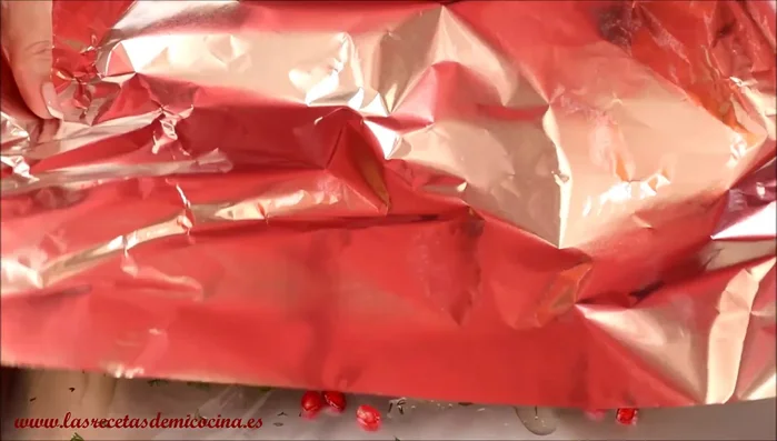 Cierra el papillote: Cubre la lubina con otra hoja de papel de aluminio, sellando bien los bordes para crear un paquete hermético.
