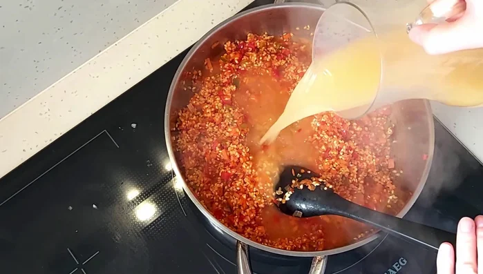 Añadir el litro de caldo de pescado y los guisantes congelados. Cocinar 10 minutos. (321.419)