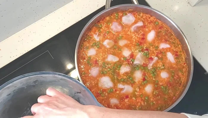 Agregar los trozos de rape y repartirlos por encima del arroz, hundiéndolos ligeramente. (373.8)