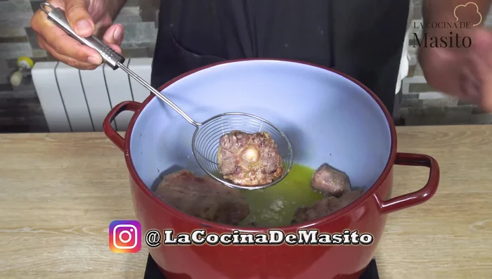 Retirar el rabo de toro de la cazuela.