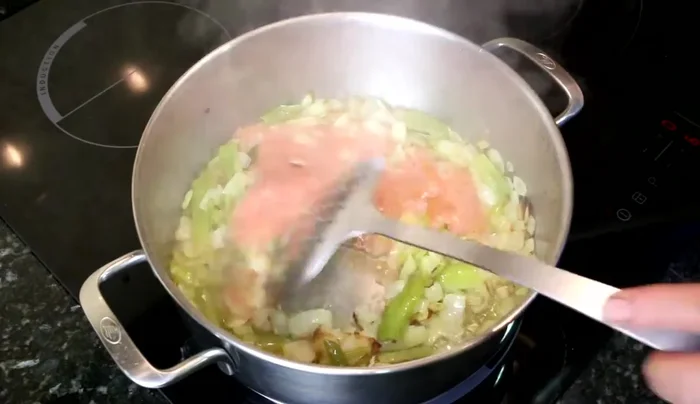Una vez tierna la cebolla y el pimiento, agregamos el tomate, el vino blanco, el pimentón, la pimienta y sal al gusto.