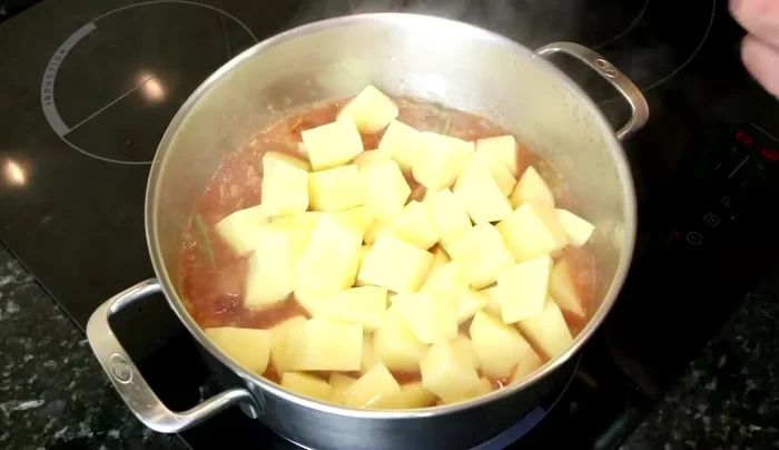 Incorporamos las patatas, los ajos, el pimiento choricero, y aproximadamente un litro de agua.